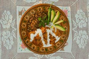 nel Messico, tradizionale chilaquiles siamo servito su un' tavolo con colorato stoviglie e fresco ingredienti. foto