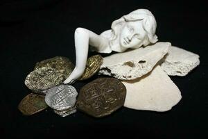 sirena posa su conchiglie toccante monete a partire dal un' Tesoro il petto. foto