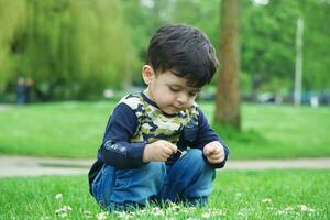 carino asiatico pakistano bambino è godendo il bellissimo soleggiato giorno a guerra bambini e pubblico parco di luton cittadina di Inghilterra UK. Basso angolo Immagine era catturato su aprile 03, 2023 foto