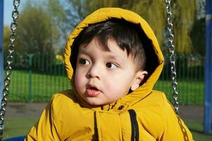 carino asiatico pakistano bambino è godendo bellissimo soleggiato e freddo giorno a lewsey pubblico parco di luton cittadina di Inghilterra UK. Basso angolo Immagine era catturato su aprile 03, 2023 foto