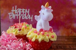 contento compleanno cupcakes con nastro e un' unicorno foto