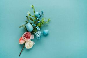 un' delicato mazzo di fiori con Pasqua uova. superiore Visualizza su un' blu sfondo. foto