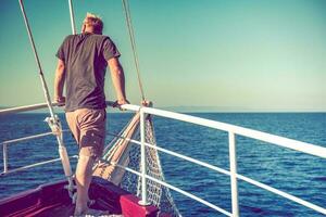 uomo godendo il suo vacanza di il mare a il arco di il barca foto