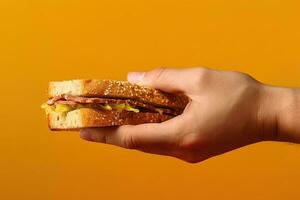 mano Tenere gustoso Sandwich su un' giallo sfondo. ai generato foto
