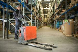 caucasico lavoratore nel uniforme con pallet Jack foto