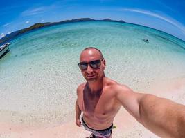 uomo caucasico fa selfie sulla spiaggia di flores taka makassar foto