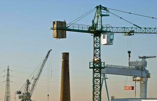 industriale orizzonte con gru, camini, piloni foto