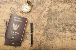 pianificazione del concetto di viaggio, passaporto thailandese sulla vecchia mappa foto
