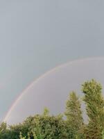 pieno arcobaleno dopo pioggia contro il cielo foto