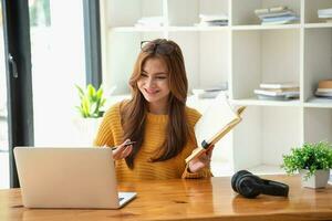 contento latino ragazza Università alunno Guardando distanza in linea apprendimento classe, a distanza Università seminario web o avendo parlare su il computer portatile video chiamata e uso taccuino per virtuale incontro seminario a casa o città universitaria foto