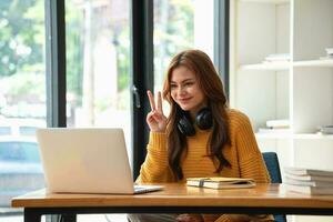 contento latino ragazza Università alunno Guardando distanza in linea apprendimento classe, a distanza Università seminario web o avendo parlare su il computer portatile video chiamata e uso taccuino per virtuale incontro seminario a casa o città universitaria foto