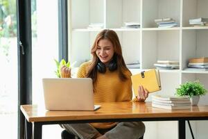 contento latino ragazza Università alunno Guardando distanza in linea apprendimento classe, a distanza Università seminario web o avendo parlare su il computer portatile video chiamata e uso taccuino per virtuale incontro seminario a casa o città universitaria foto