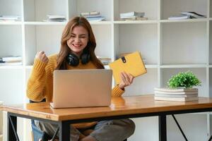 contento latino ragazza Università alunno Guardando distanza in linea apprendimento classe, a distanza Università seminario web o avendo parlare su il computer portatile video chiamata e uso taccuino per virtuale incontro seminario a casa o città universitaria foto