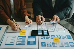 UX sviluppatore e ui progettista di brainstorming di mobile App interfaccia wireframe design con cliente breve e colore codice a ufficio. foto