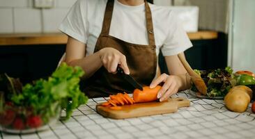 vicino su giovane donna mani preparazione un' salutare insalata. taglio verdure pomodori su un' taglio tavola su il casa foto