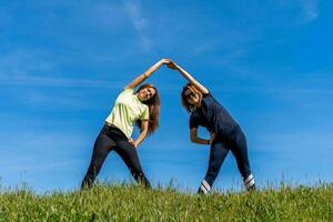 coppia di bella atletico donne fare ginnastica esercizi all'aperto foto