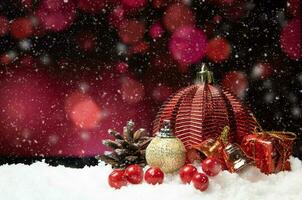 bellissimo Natale decorazione su neve con rosso bokeh sfondo foto