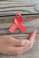 mondo AIDS giorno, mano con rosso nastro simbolo foto