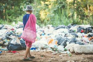 un' triste bambino è Lavorando a un' spazzatura scarico, concetti di bambino lavoro duro e faticoso e umano traffico. foto
