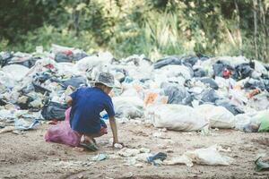 i bambini poveri raccolgono immondizia per la vendita a causa della povertà, il riciclaggio della spazzatura, il lavoro minorile, il concetto di povertà, la giornata mondiale dell'ambiente, foto