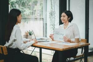 femmina operazioni manager detiene incontro presentazione per un' squadra di economisti. asiatico donna usi attività commerciale carta con crescita analisi, grafici, statistica e dati. foto