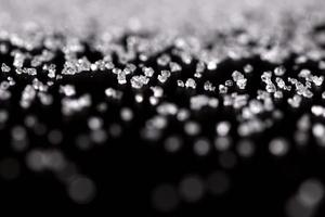 zucchero cristallino bianco su sfondo nero foto