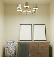 classico Guarda telaio modello manifesto in piedi su il vecchio di legno tavolo con vaso e lusso lampada decorazione su il beige parete foto