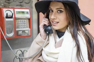 giovane donna alla cabina telefonica foto