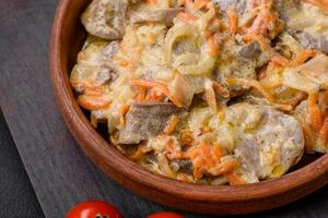 delizioso bollito Manzo o Maiale lingua affettato con carote, cipolle, acida crema e spezie foto