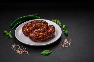 delizioso grigliato salsiccia nel il modulo di un' squillare con sale, spezie e erbe aromatiche foto