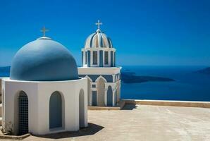 cupole su il tetto di il Chiesa di st marchio il evangelista e il Egeo mare su il fira città a santorini isola foto