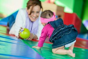 bellissimo dieci mesi bambino ragazza giocando con sua mamma. presto stimolazione per bambini piccoli concetto. foto