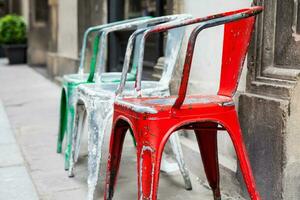 tre vuoto traballante colorato sedie a il storico strade di Firenze foto