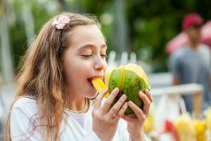 bellissimo giovane ragazza a paseo bolivar piazza nel il città di cali mangiare tropicale frutta nel Colombia foto