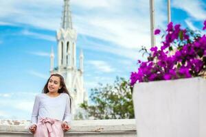 bellissimo giovane ragazza su il ortiz ponte con il famoso Gotico Chiesa di la ermita nel il città di cali nel Colombia foto