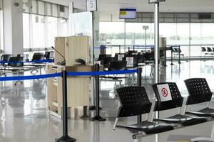 vuoto wating camera a un aeroporto durante covid 19 pandemia con sociale distanziamento segni su sedie foto