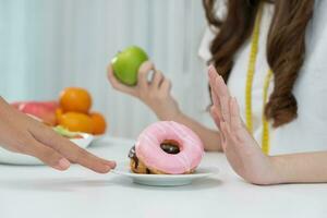 dieta e stare a dieta. bellezza sottile femmina corpo confuso ciambella. donna nel esercizio Abiti ottiene peso perdita obbiettivo per salutare vita, pazzo di magrezza, magro vita, nutrizionista. foto