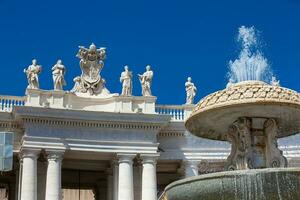 Fontana e dettaglio di il chigi cappotti di braccia e il statue di santi quello corona il colonnati di st. Peter piazza costruito su 1667 su il Vaticano città foto