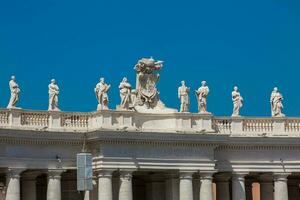 dettaglio di il chigi cappotti di braccia e il statue di santi quello corona il colonnati di st. Peter piazza costruito su 1667 su il Vaticano città foto