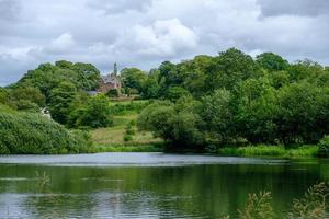 stagno e casa tradizionale vicino alla capanna di ammissione nel parco di Lyme, disley nel cheshire, Regno Unito foto