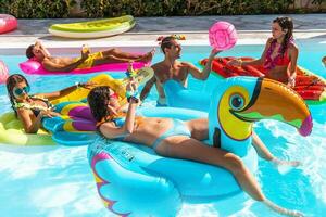 gruppo di amico giocare insieme nel il nuoto piscina foto