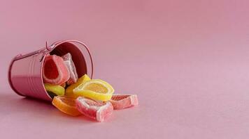 colorato frutta gelatina caramella nel un' rosa secchio foto