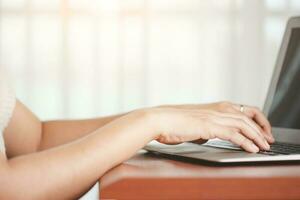 asiatico donna di mano utilizzando un' computer il computer portatile foto