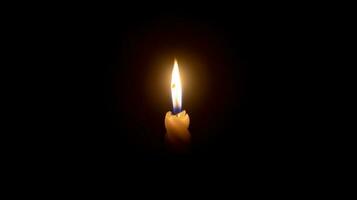 un' singolo ardente candela fiamma o leggero raggiante su un' bianca spirale candela su nero o buio sfondo su tavolo nel Chiesa per Natale, funerale o memoriale servizio con copia spazio. foto