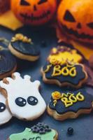 biscotti di panpepato di halloween su sfondo scuro, con mini zucche di halloween e decorazioni foto