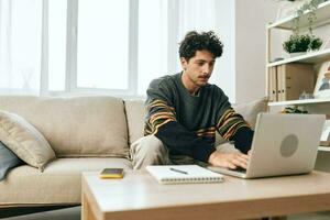 il computer portatile uomo tipo Internet casa attività commerciale Lavorando libero professionista computer stile di vita divano digitando in linea Sorridi foto