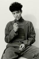 uomo fumo seduta moda nero ritratto riflessivo sigaretta e bianca foto