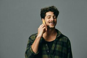 capelli uomo Sorridi guardare studio tecnologia Telefono elegante sfondo grigio contento tipo stile di vita foto