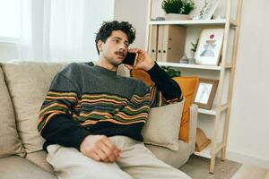 uomo stile di vita Telefono cellula divano casa Sorridi foto