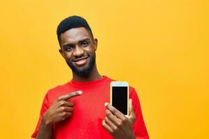 giovane uomo africano spazio Telefono copia cellula tecnologia mobile contento giallo sfondo nero foto